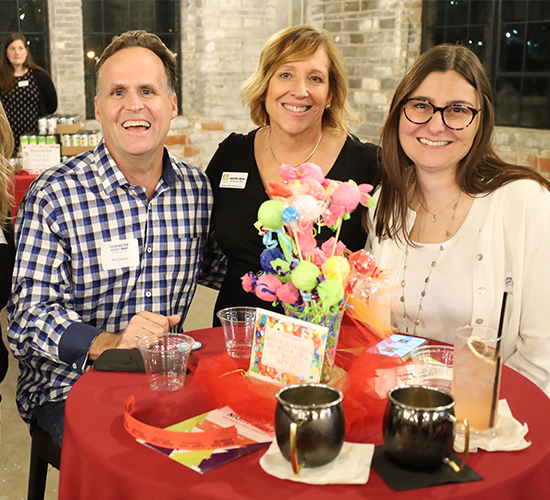 Jennifer hines and guests at camping the night away smiling at table with fun decor