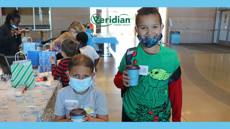 kids drinking cocoa at holiday dropoff with veridian logo