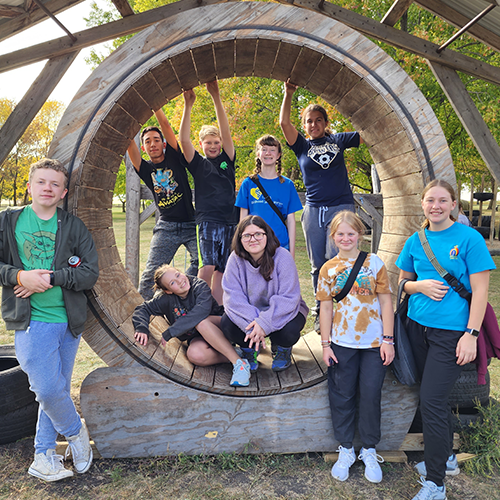 teens inside a wooden wheel at teen camp