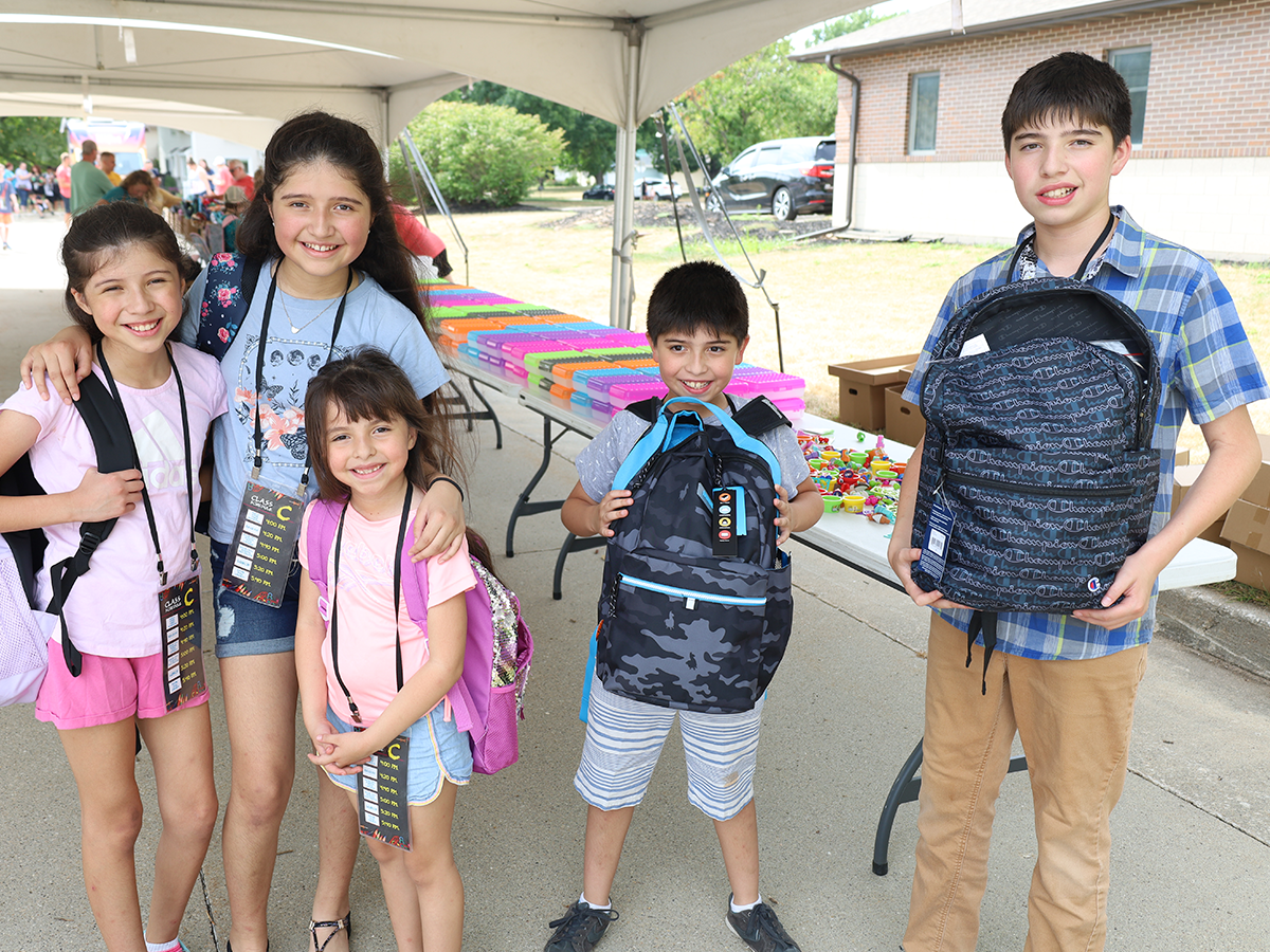 family showing off new backpacks and back-to-school bash