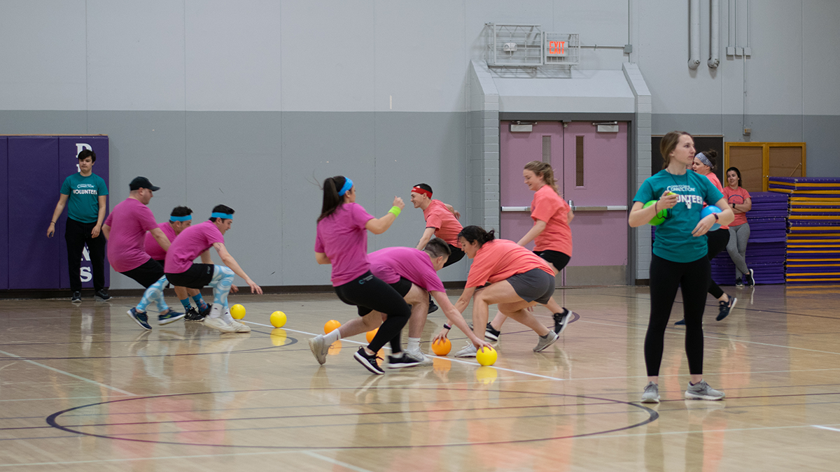 Teams of dodgeball players racing toward dodgeballs
