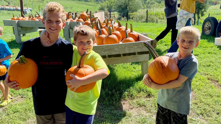 photo of kids holding pumpkins