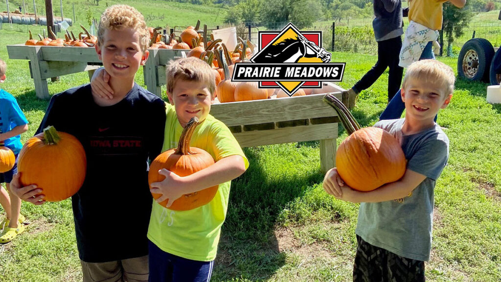 photo of kids holding pumpkins and the prairie meadows logo