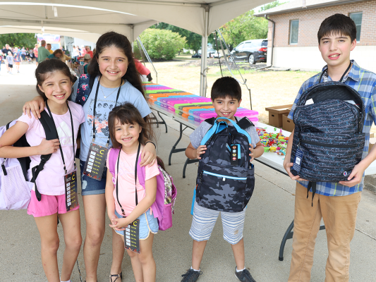 back to school family showing new backpacks