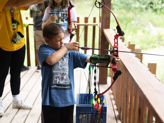 kids doing archery at camp